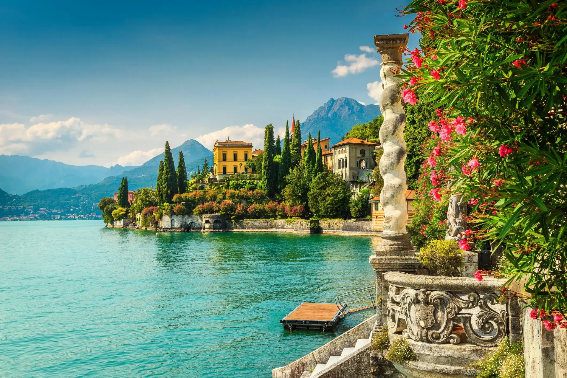 Italian lakeside villas and cypress trees above turquoise water